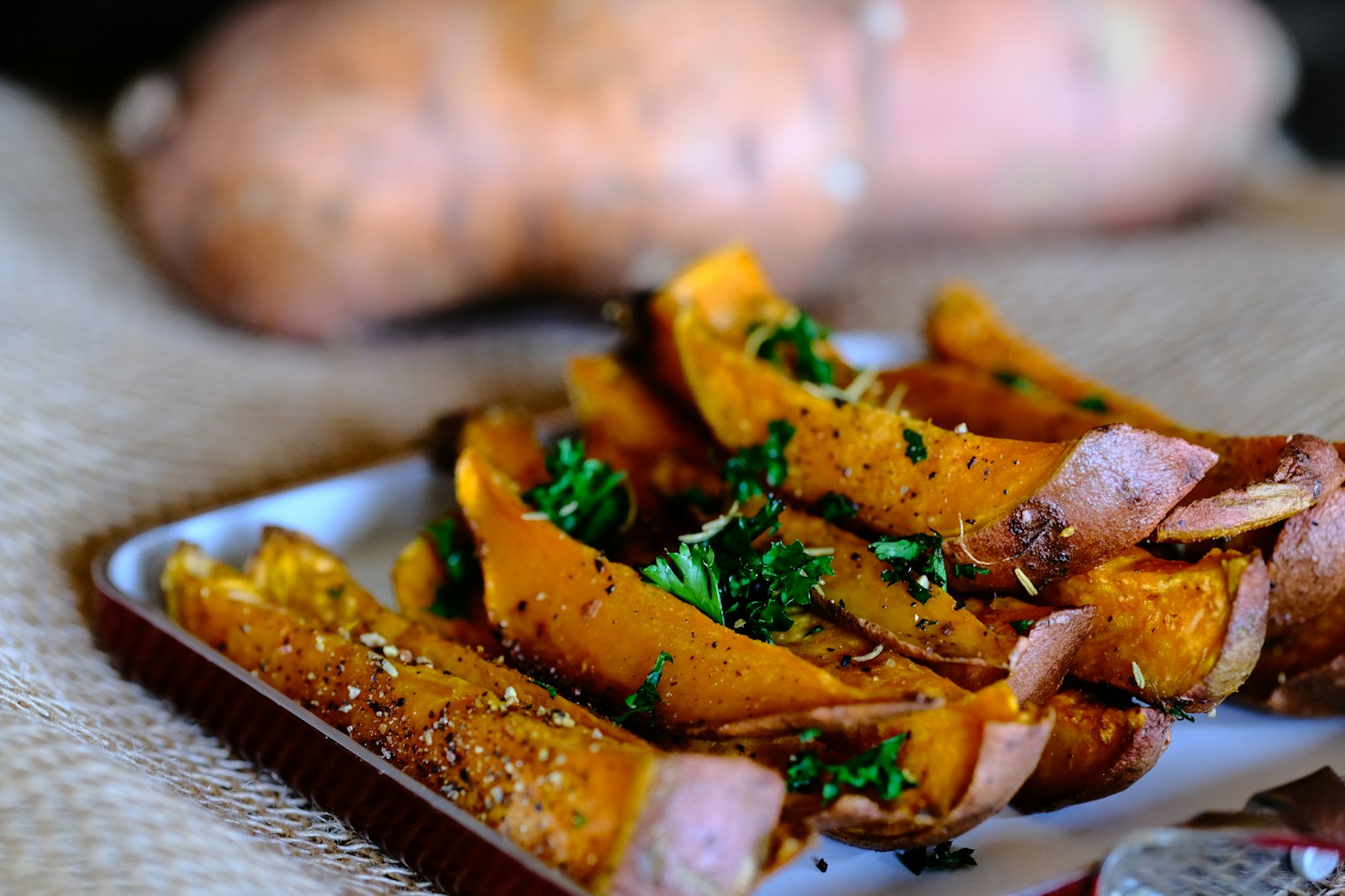 Sliced sweet potato prepared on a wooden cutting board